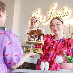 Medarbejder holder brunch frem, som kollega tager i mod