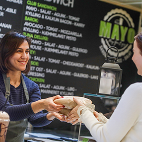 Ekspedient står med to friskpressede juice hos sandwich og juicebaren Mayo i Slagelse