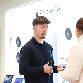 Medarbejder viser kunde Iphone i butik